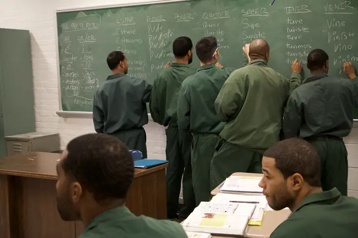 Bard Prison Initiative (BPI) students conjugate Spanish verbs on a chalkboard at Eastern New York Correctional Facility.